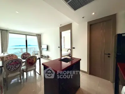Luxurious open-plan kitchen with stunning sea view and elegant dining area.