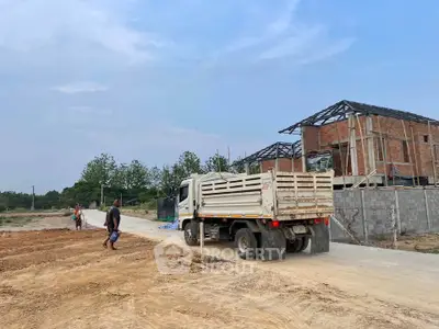 Construction site with truck and partially built houses under blue sky