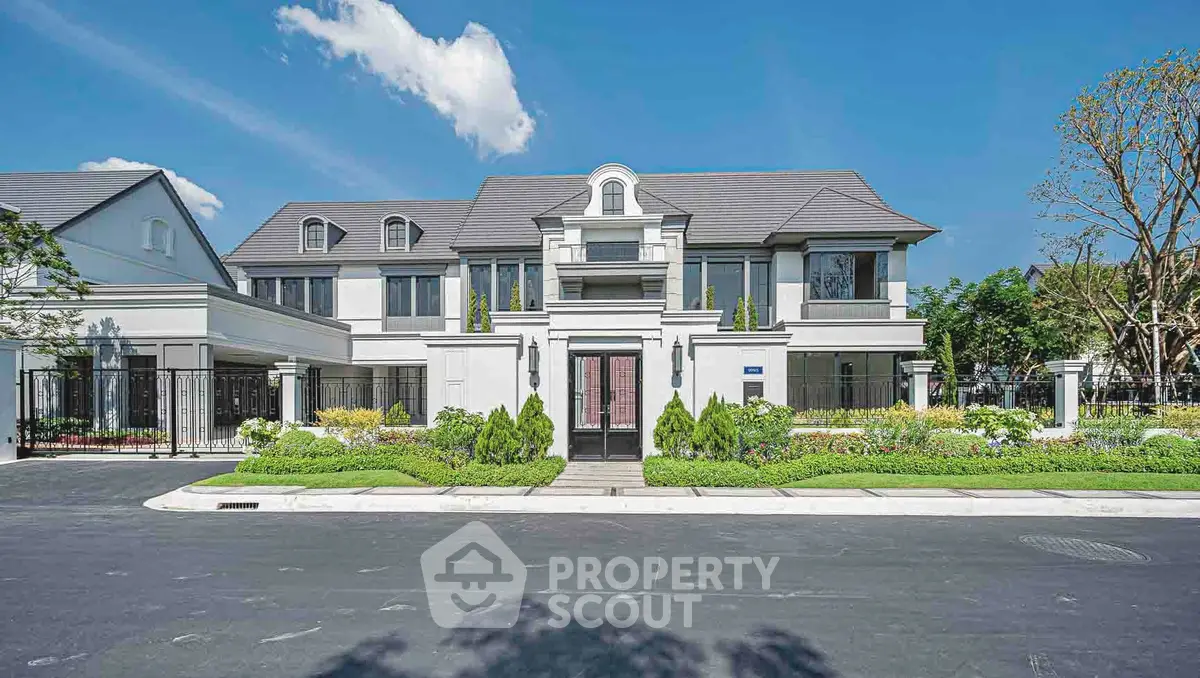 Luxurious modern mansion with elegant facade and lush landscaping under a clear blue sky.