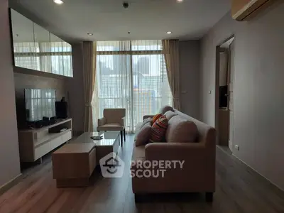 Modern living room with stylish furniture and large windows offering natural light.