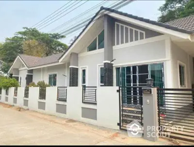 Modern single-story house with stylish facade and gated entrance