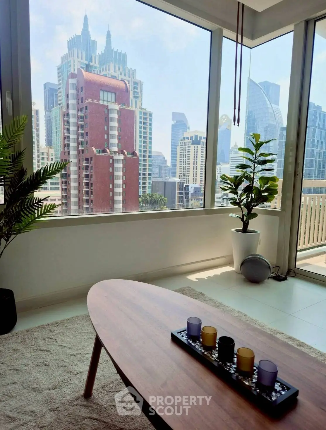 Stunning city view from modern living room with large windows and stylish decor.