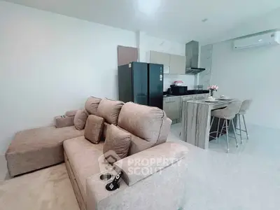 Modern open-plan living room with cozy sofa and sleek kitchen area