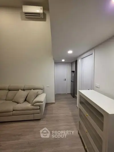 Modern living room with sleek design and neutral tones, featuring a comfortable sofa and stylish storage unit.