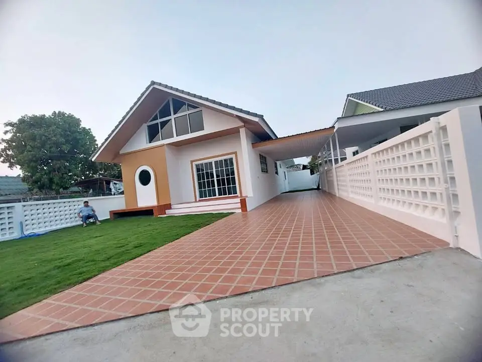 Charming single-story home with spacious driveway and lush green lawn.