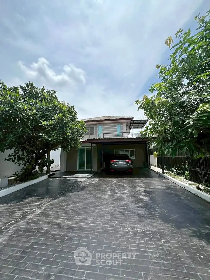 Charming two-story house with spacious driveway and lush greenery.