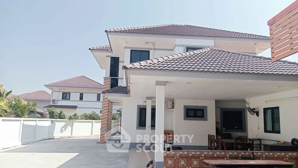 Spacious modern two-story house with tiled roof and large driveway in a serene neighborhood.