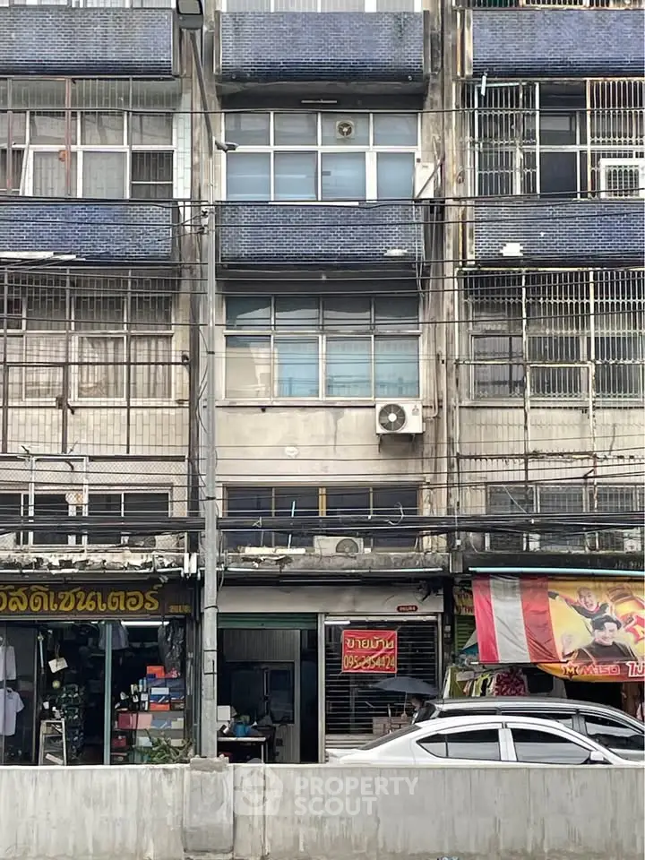 Urban building exterior with retail shops and residential units, showcasing city living and commercial opportunities.