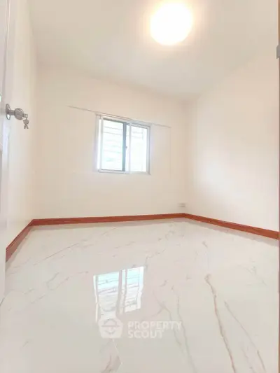 Bright and airy bedroom with glossy marble flooring and natural light.