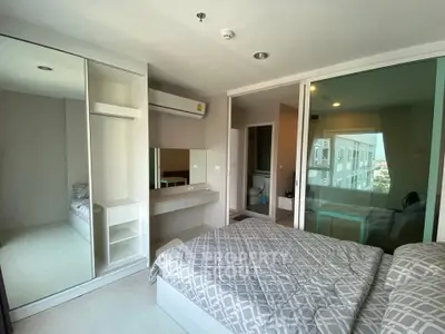 Modern bedroom with mirrored wardrobe and ensuite bathroom in a stylish apartment.