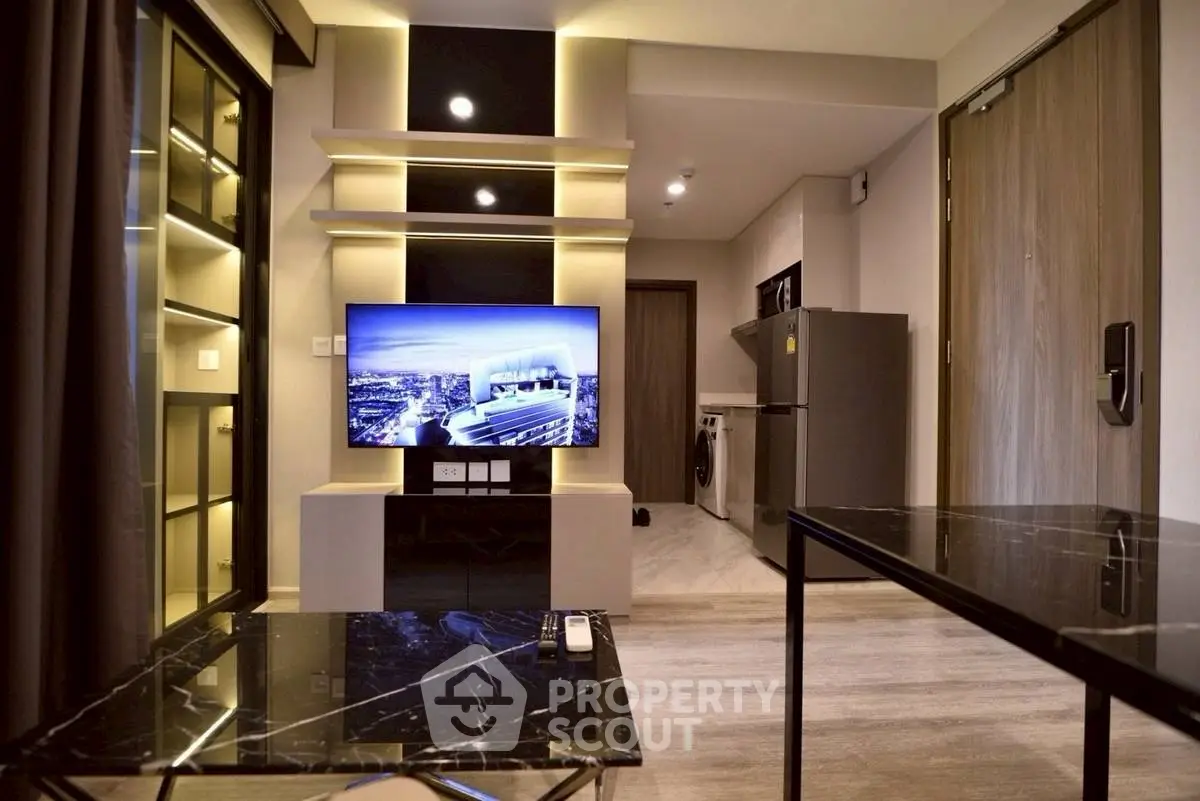 Modern living room with sleek TV setup and open kitchen layout