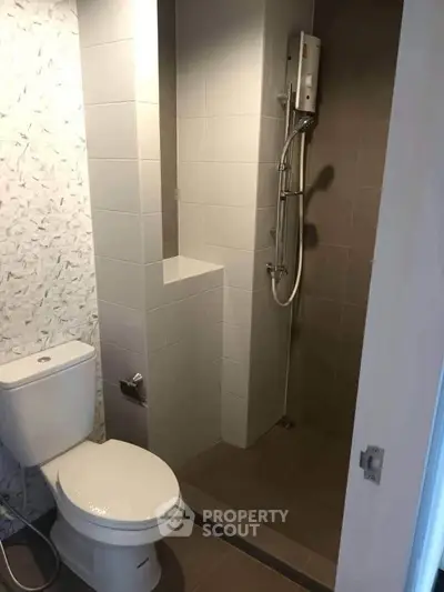 Modern bathroom with sleek shower and toilet in a compact space.