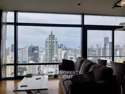 Luxurious living room with stunning city skyline view from large windows.