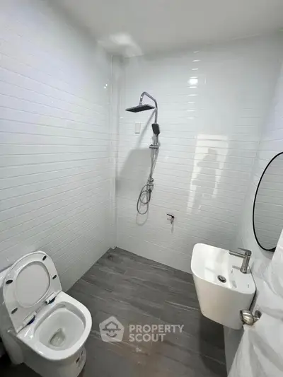 Modern minimalist bathroom with sleek fixtures and white tile walls.