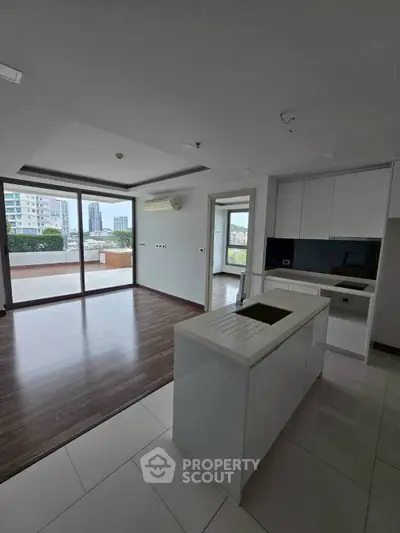 Spacious modern kitchen with open layout and large balcony view.