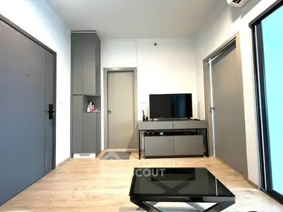 Modern living room with sleek furniture and minimalist design, featuring a TV and stylish coffee table.