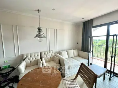 Charming living room with elegant white sofas and natural light from balcony view.