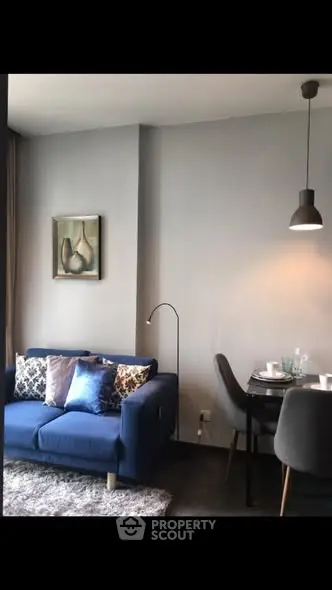 Modern living room with stylish blue sofa and dining area, perfect for urban living.