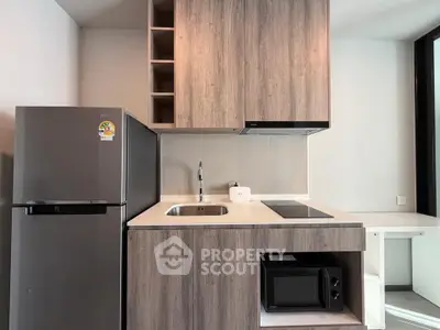 Modern compact kitchen with sleek cabinetry and appliances in a stylish apartment.