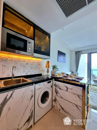 Modern kitchen with marble countertops, built-in appliances, and ocean view