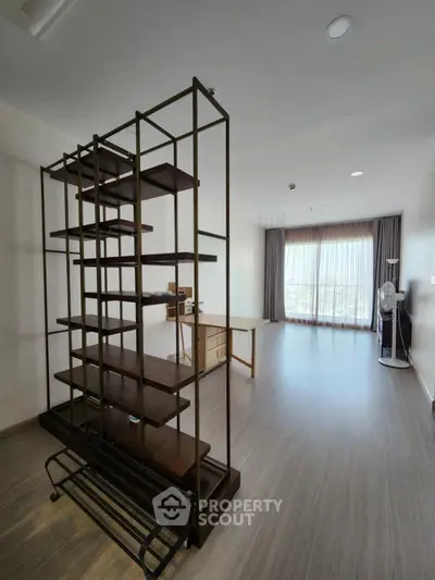 Spacious modern living room with large windows and stylish shelving unit