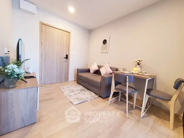 Cozy living room with modern decor and dining area in a stylish apartment.