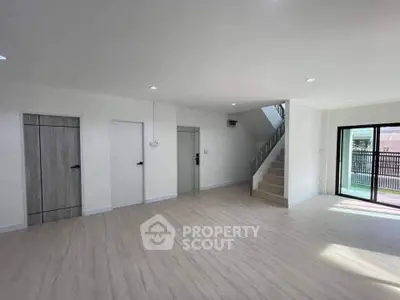 Spacious modern living room with staircase and large windows