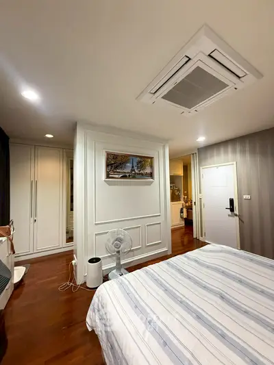 Spacious bedroom with modern decor and wooden flooring