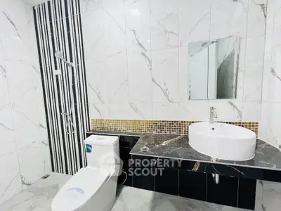Modern bathroom with sleek design, featuring a stylish sink and elegant tile work.