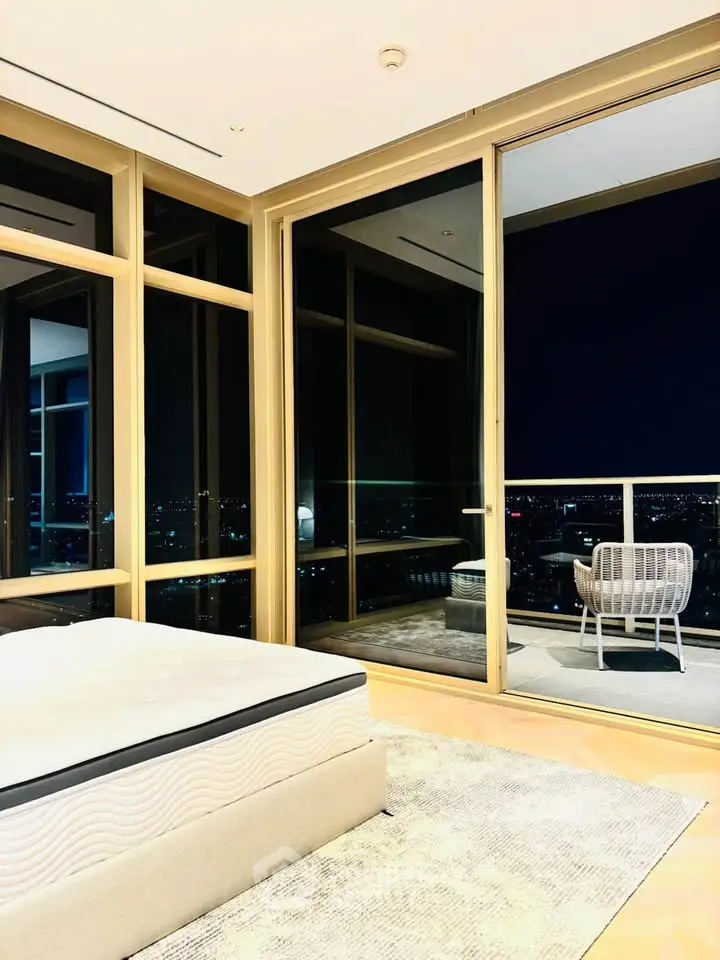Luxurious bedroom with floor-to-ceiling windows and stunning city view balcony.