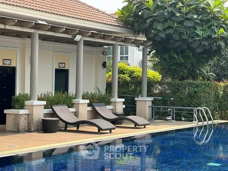 Luxurious poolside area with stylish loungers and lush greenery