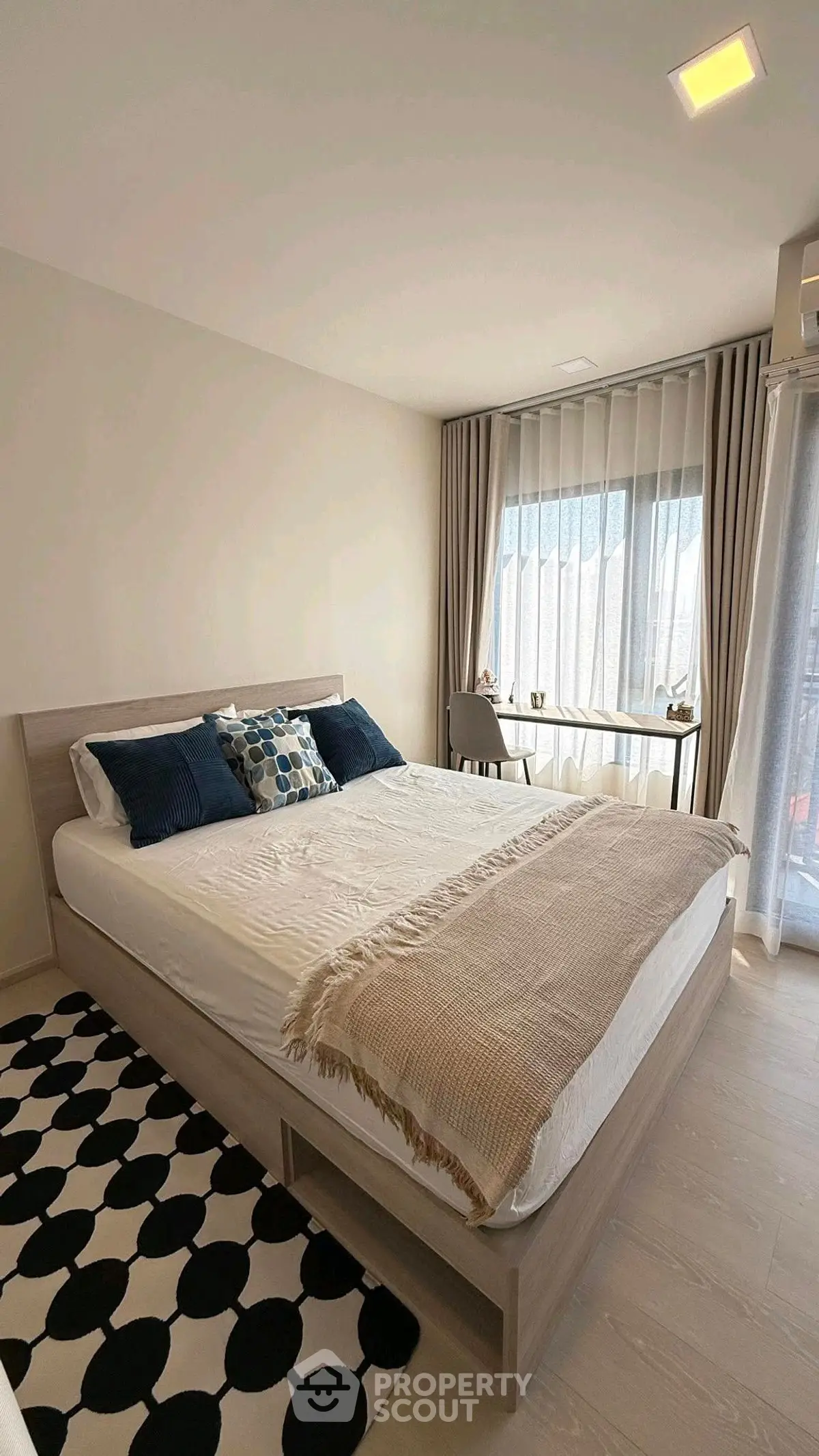 Modern bedroom with stylish decor and large window for natural light