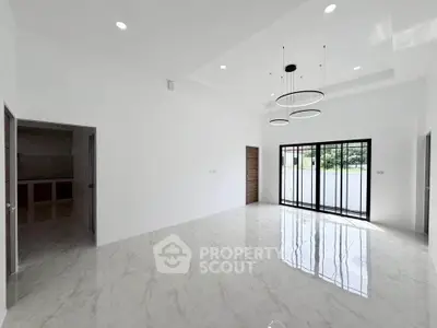 Spacious modern living room with elegant lighting and large windows for natural light.