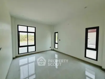 Spacious empty room with large windows and natural light