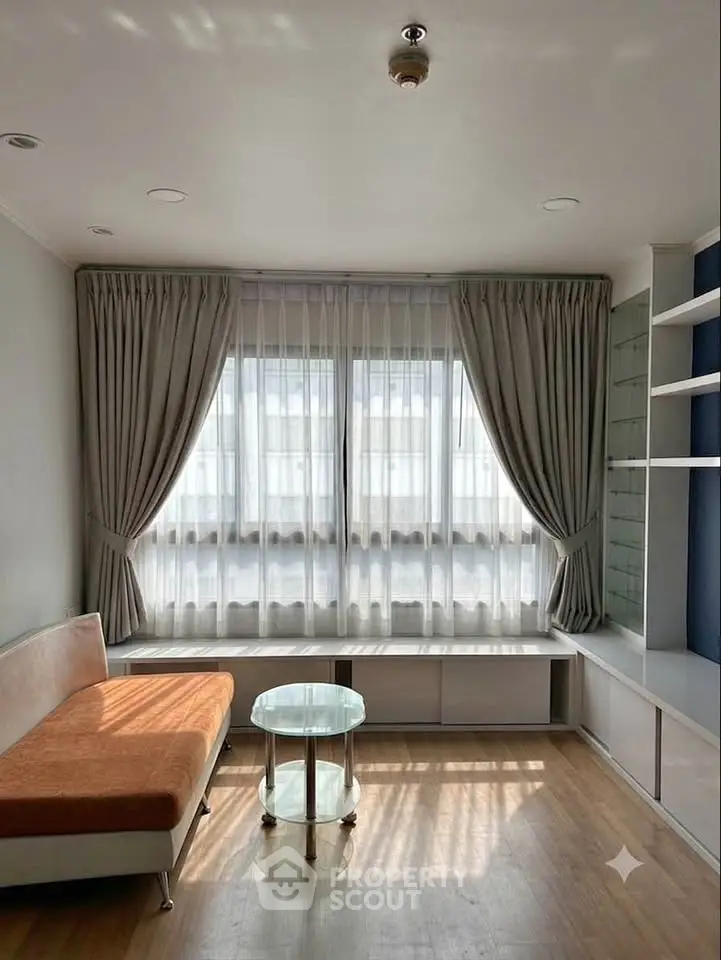 Bright living room with modern sofa and large window, perfect for relaxation.