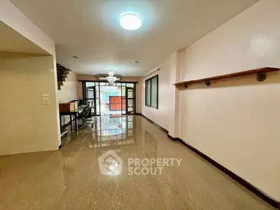 Spacious living room with glossy floors and large windows for natural light