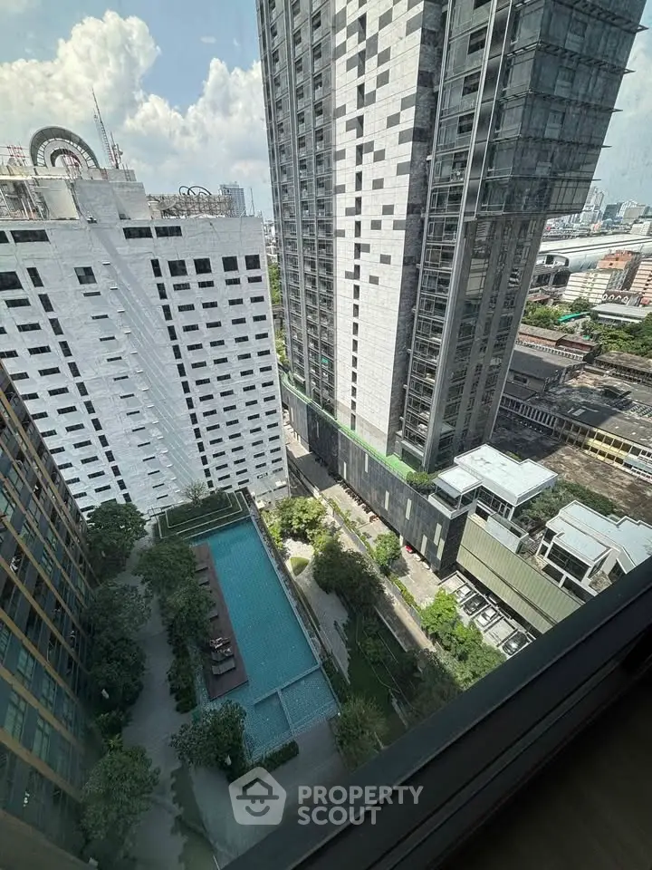 Stunning high-rise view with pool and cityscape from a modern apartment window.