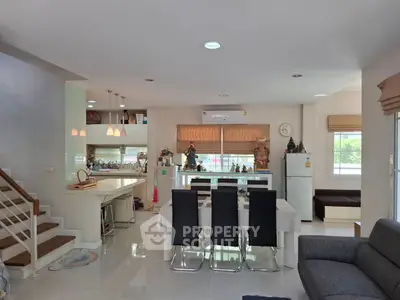 Spacious modern living and dining area with open kitchen layout and elegant decor.