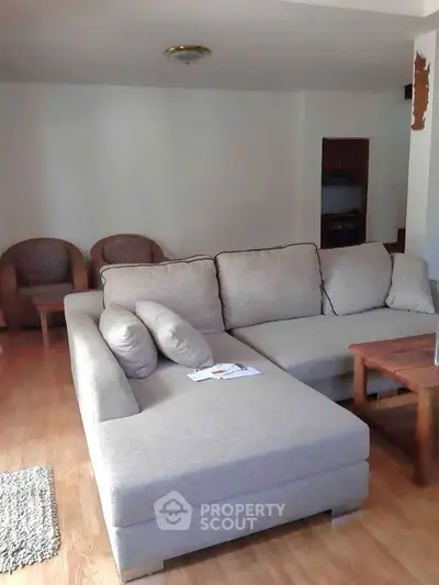 Spacious living room with cozy sectional sofa and wooden flooring