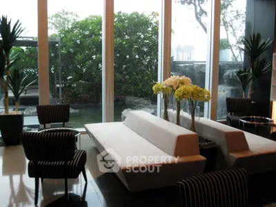 Luxurious modern living room with large windows and garden view, featuring elegant furniture and stylish decor.