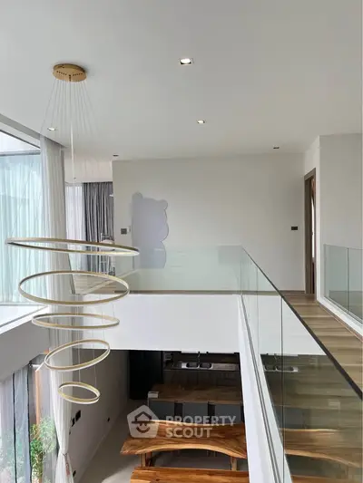 Modern duplex interior with stylish spiral chandelier and wooden dining table