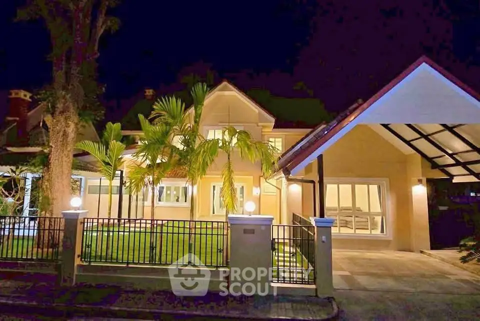 Stunning night view of a luxurious villa with lush garden and modern architecture.