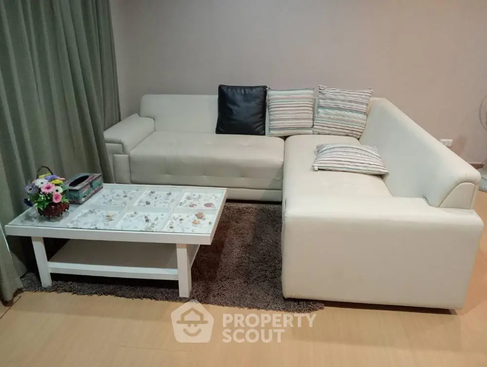 Stylish living room with modern white sectional sofa and elegant coffee table.