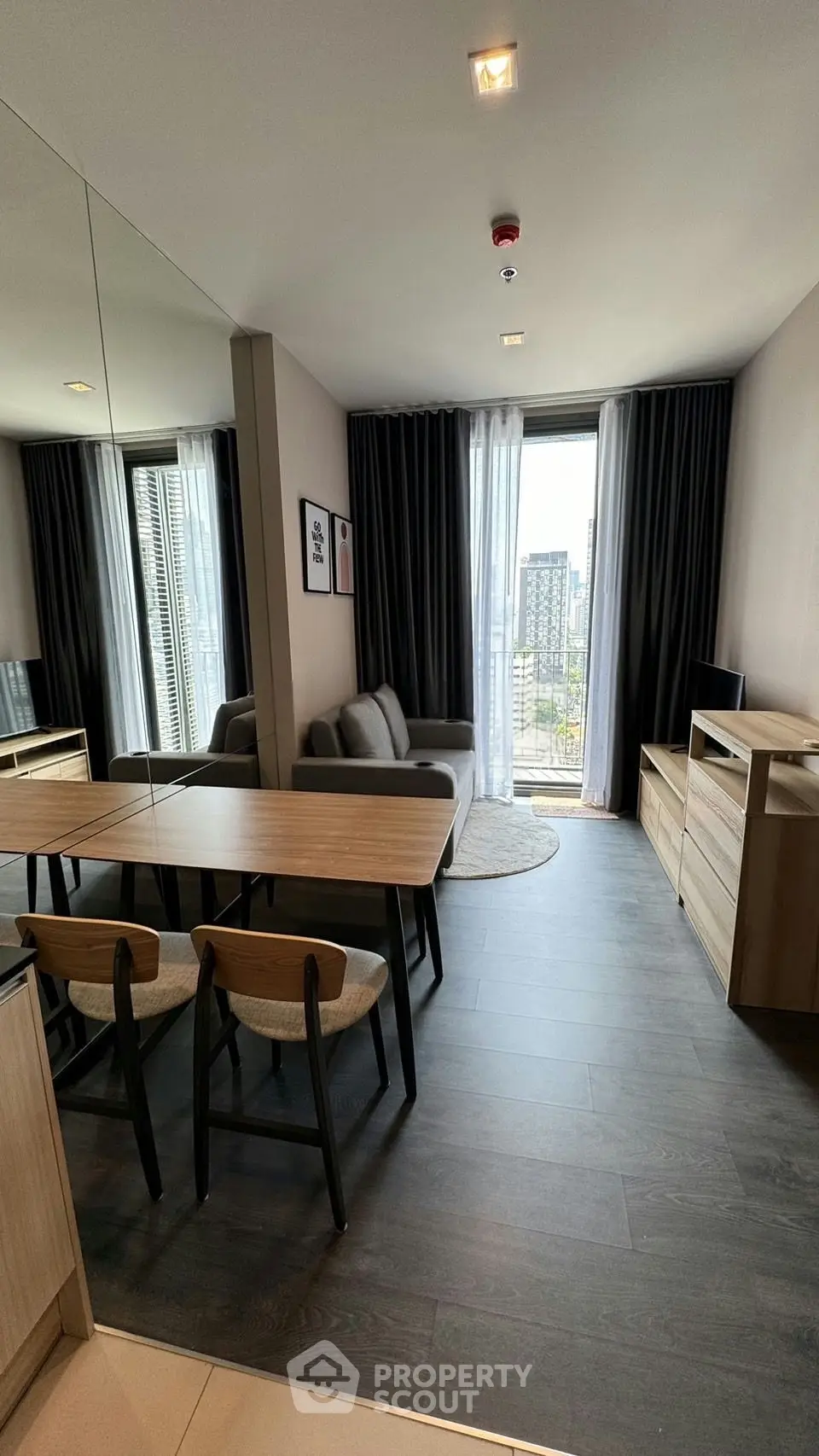 Modern living room with sleek furniture and large window offering city view