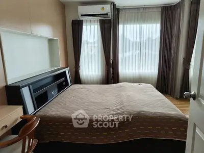 Cozy bedroom with large windows and modern furnishings, perfect for relaxation and comfort.