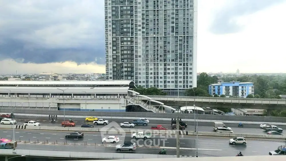 Stunning urban view with modern high-rise building and busy highway, perfect for city living enthusiasts.