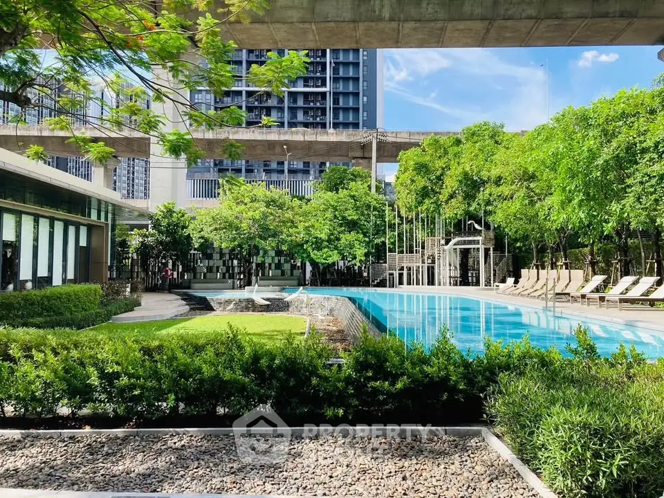 Luxurious residential pool area with lush greenery and modern architecture, perfect for relaxation and leisure.