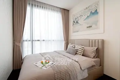 Cozy bedroom with elegant decor and large window, perfect for relaxation.