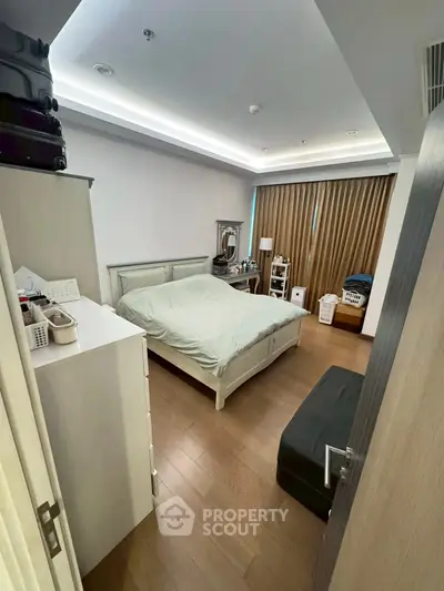 Cozy bedroom with modern decor and ample storage space, featuring a comfortable bed and stylish lighting.