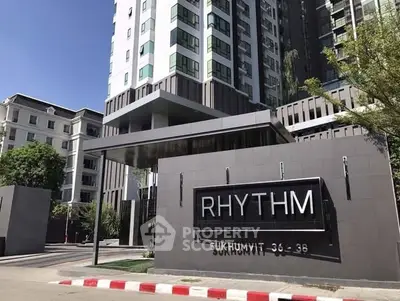 Modern condominium exterior with sleek design and prominent signage in urban setting.